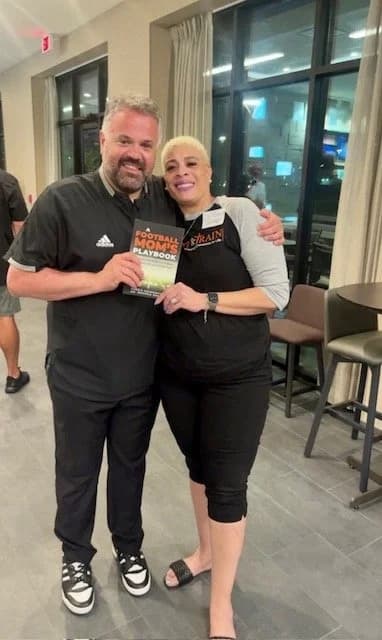 A reader with his copy of A Football Mom's Playbook