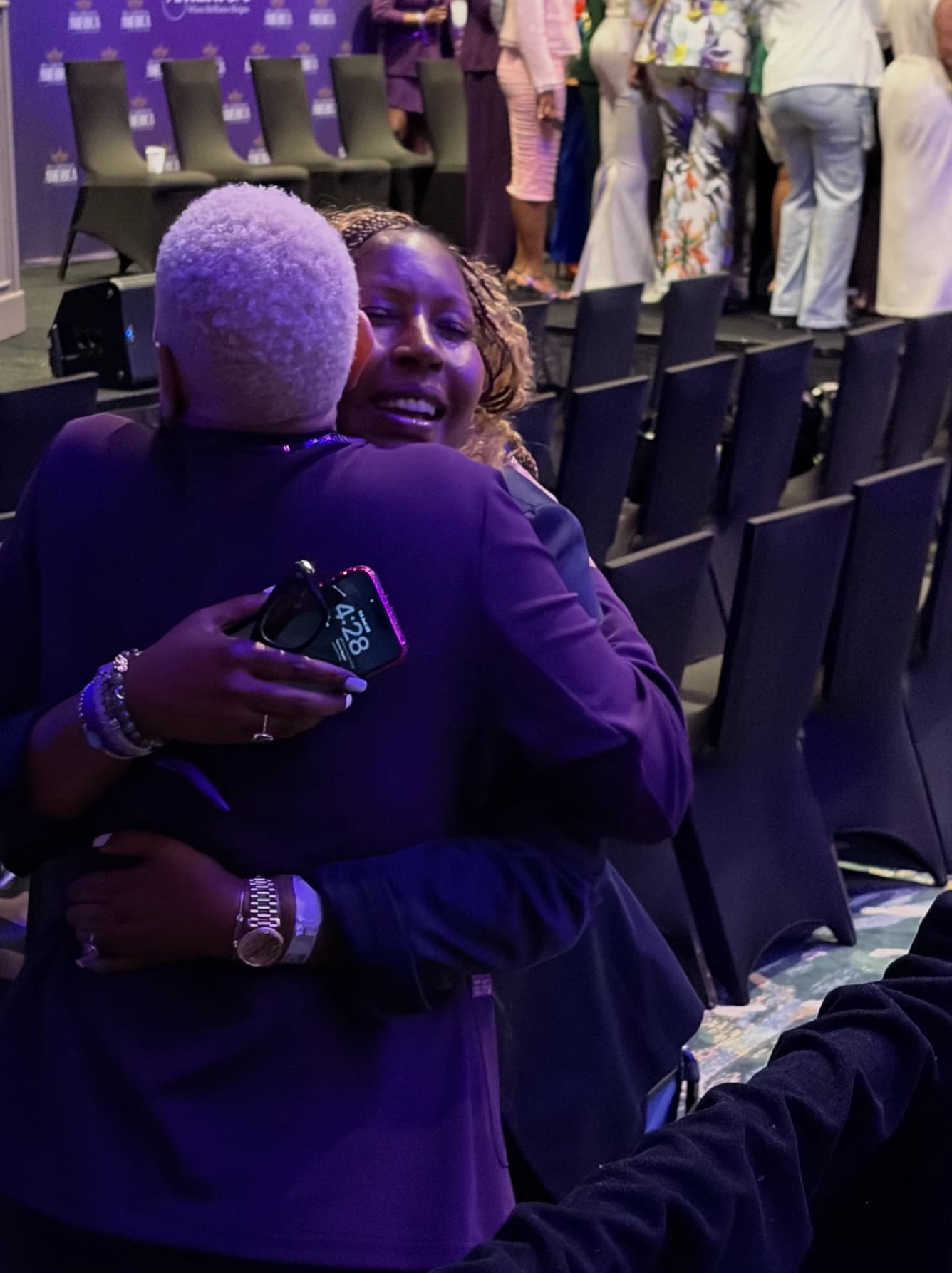 Dr. Sneed sharing an emotional embrace near the stage